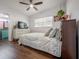 Bedroom with laminate flooring, neutral bedding, dresser with television, and natural light at 7108 N Howard Ave, Tampa, FL 33604