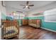 Bedroom featuring two wooden cribs, natural light, and laminate flooring at 7108 N Howard Ave, Tampa, FL 33604
