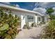 Inviting front porch with seating, surrounded by lush landscaping and charming green shutters at 7108 N Howard Ave, Tampa, FL 33604