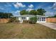 Charming ranch-style home featuring a lush front yard, green shutters, and a cozy front patio at 7108 N Howard Ave, Tampa, FL 33604