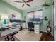 Bright office space with mint green walls, two monitors, a keyboard, guitar, and laminate flooring at 7108 N Howard Ave, Tampa, FL 33604