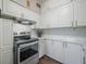 Updated kitchen with white cabinets, stainless steel oven, and modern countertops with decorative accents at 7108 N Howard Ave, Tampa, FL 33604