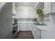 Well-lit kitchen featuring white cabinets, stainless steel appliances, and stylish countertops at 7108 N Howard Ave, Tampa, FL 33604