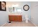 Bathroom featuring wood cabinet vanity, mirror, clock, toilet and tile floors at 7120 Early Gold Ln, Riverview, FL 33578