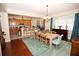Open dining area with wood floors, dining table and view to kitchen with counter bar seating at 7120 Early Gold Ln, Riverview, FL 33578