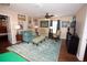Comfortable living room with teal-colored decor, an area rug, and several pieces of framed artwork on the wall at 7120 Early Gold Ln, Riverview, FL 33578