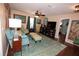 Cozy living room with blue sofa, patterned rug, and a ceiling fan, complete with a large TV and decorative wall art at 7120 Early Gold Ln, Riverview, FL 33578