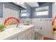 Bright bathroom with blue walls, white vanity, large mirror, and decorative shower curtain at 7337 Glasgow Rd, Weeki Wachee, FL 34613