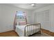 Bedroom with wood floors, white walls, window with sheer curtains, and large closet at 7337 Glasgow Rd, Weeki Wachee, FL 34613