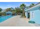 Community pool area with blue buildings, palm trees, and ample lounge seating for residents at 7337 Glasgow Rd, Weeki Wachee, FL 34613