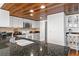 Modern kitchen with white cabinets, granite counters, wood ceiling, and stainless steel appliances at 7337 Glasgow Rd, Weeki Wachee, FL 34613