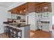 Kitchen with dark granite countertops, bright white cabinets, and a unique wood-paneled ceiling at 7337 Glasgow Rd, Weeki Wachee, FL 34613