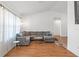 Bright living room featuring a large sectional sofa, wooden floors, and vaulted ceiling at 7337 Glasgow Rd, Weeki Wachee, FL 34613