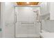 An accessible shower with tiled walls, wood trim, and a safety bar at 7337 Glasgow Rd, Weeki Wachee, FL 34613