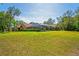 Expansive backyard featuring a screened-in pool enclosure and lush green lawn at 7353 Dogwood Cres, Spring Hill, FL 34607