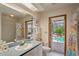 Bathroom with a vanity, shower, toilet, and an exterior door leading to the pool area at 7353 Dogwood Cres, Spring Hill, FL 34607