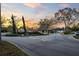 Welcoming entrance to the community, featuring lush landscaping and an idyllic, sunset backdrop at 7353 Dogwood Cres, Spring Hill, FL 34607