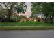 Exterior shot of home with lush green lawn and mature trees at 7353 Dogwood Cres, Spring Hill, FL 34607