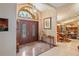 Elegant foyer with grand double doors, marble floors, and decorative lighting fixture at 7353 Dogwood Cres, Spring Hill, FL 34607