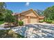 Three-car garage showcasing stone accents and a well-maintained driveway, creating a welcoming entrance at 7353 Dogwood Cres, Spring Hill, FL 34607