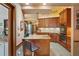 Cozy kitchen with granite island, stainless appliances, and wood cabinets at 7353 Dogwood Cres, Spring Hill, FL 34607