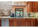 Well-lit kitchen with granite countertops, wood cabinets, and a view of the backyard at 7353 Dogwood Cres, Spring Hill, FL 34607