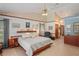 Neutral-toned main bedroom featuring a ceiling fan, artwork, and an ensuite at 7353 Dogwood Cres, Spring Hill, FL 34607
