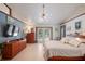 Spacious main bedroom featuring a ceiling fan, dresser, and doors leading to the pool area at 7353 Dogwood Cres, Spring Hill, FL 34607