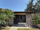 Charming single-story home with a brick facade, a screened-in porch, and mature landscaping at 7360 Ulmerton Rd # 20F, Largo, FL 33771
