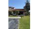 Charming home featuring a red tile roof, palm trees, and green lawn, offering curb appeal at 7360 Ulmerton Rd # 20F, Largo, FL 33771