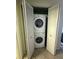 Convenient laundry closet with stacked washer and dryer units and white folding doors at 7360 Ulmerton Rd # 20F, Largo, FL 33771