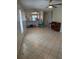 An open-concept living room with tile flooring, ceiling fans, and views into the kitchen at 7360 Ulmerton Rd # 20F, Largo, FL 33771