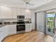 Bright kitchen featuring white cabinets, stainless steel appliances, and balcony access at 7500 Sunshine Skyway S Ln # 201, St Petersburg, FL 33711