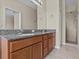Bathroom featuring double sinks with stone countertops, a shower, and neutral tiling at 800 Callista Cay Loop, Tarpon Springs, FL 34689