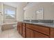 Bathroom featuring a tub, a window, a toilet and a double sink vanity with stone countertops at 800 Callista Cay Loop, Tarpon Springs, FL 34689