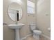 This bathroom has a pedestal sink, toilet, and a decorative oval mirror at 800 Callista Cay Loop, Tarpon Springs, FL 34689