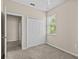 Well-lit bedroom with carpet and a large window, and a view of a bright window and closet at 800 Callista Cay Loop, Tarpon Springs, FL 34689