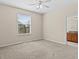 Neutral bedroom featuring carpet, ceiling fan, and a bright window with verdant trees visible at 800 Callista Cay Loop, Tarpon Springs, FL 34689