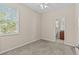 Bedroom featuring carpet, a ceiling fan, a bright window with verdant trees visible, and en suite bath at 800 Callista Cay Loop, Tarpon Springs, FL 34689