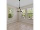 A dining room with modern lighting, tiled floors and large windows at 800 Callista Cay Loop, Tarpon Springs, FL 34689
