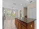 View of kitchen island with granite countertops, view to windows and dining area at 800 Callista Cay Loop, Tarpon Springs, FL 34689