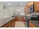 A view of the kitchen showing granite countertops, stainless steel appliances and view to another room at 800 Callista Cay Loop, Tarpon Springs, FL 34689