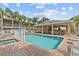 Community pool area with a covered sitting area, lounge chairs, and a beautiful swimming pool at 800 Callista Cay Loop, Tarpon Springs, FL 34689