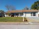 Charming single-story home featuring a well-manicured lawn, attached garage, and covered porch at 8313 Cavalry Dr, Hudson, FL 34667