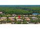 Aerial view showcases a house nestled in a lush community with a beautiful forest backdrop and lake nearby at 8434 Dunham Station Dr, Tampa, FL 33647