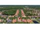 Expansive aerial view of a residential community with lush greenery and tiled roofs, pinpointing the subject property at 8434 Dunham Station Dr, Tampa, FL 33647