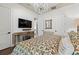 Cozy bedroom with a chandelier, console table, mounted TV, and hardwood floors at 8434 Dunham Station Dr, Tampa, FL 33647