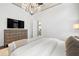 Bright bedroom features a chandelier, dresser, and a luxurious king bed at 8434 Dunham Station Dr, Tampa, FL 33647