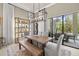 Light-filled dining room with wood table, bench seating, stylish chandelier, and view of the outdoor patio at 8434 Dunham Station Dr, Tampa, FL 33647