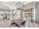Open-concept dining room with wood table, modern chandelier, and adjacent kitchen, perfect for entertaining at 8434 Dunham Station Dr, Tampa, FL 33647